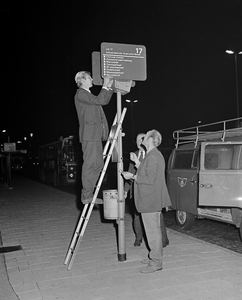 855110 Afbeelding van het plaatsen van een bord met de nieuwe route van stadsbuslijn 17 bij een bushalte op het ...